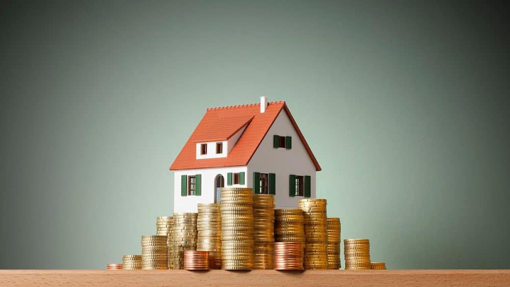 House atop stacks of coins representing property value and taxes in Riverside Township, Illinois.