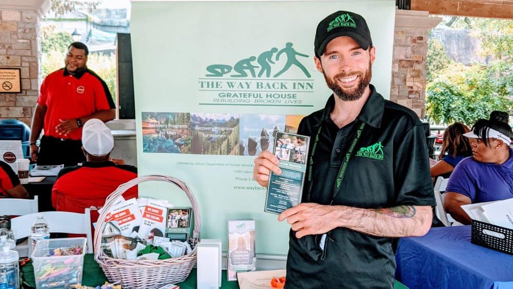 Man smiling at Riverside Township event with informational booth.