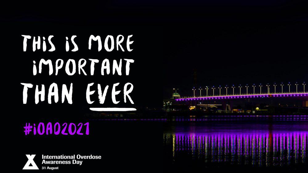 Night view of Riverside bridge lit with purple lights for Overdose Awareness Day.