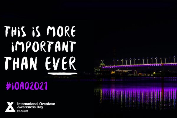 Night view of Riverside bridge lit with purple lights for Overdose Awareness Day.