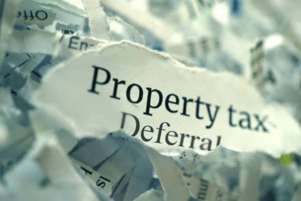 Torn paper with 'Property tax Deferral' text for senior citizens.