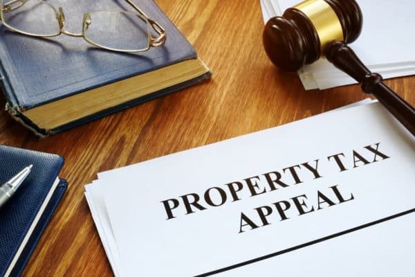Property tax appeal form with gavel and legal documents on desk.